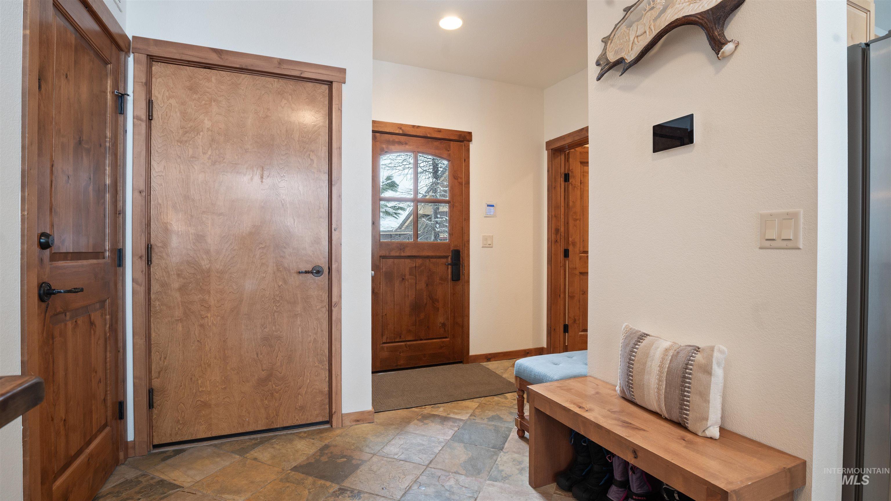 Foyer with stone finish floors and recessed lighting