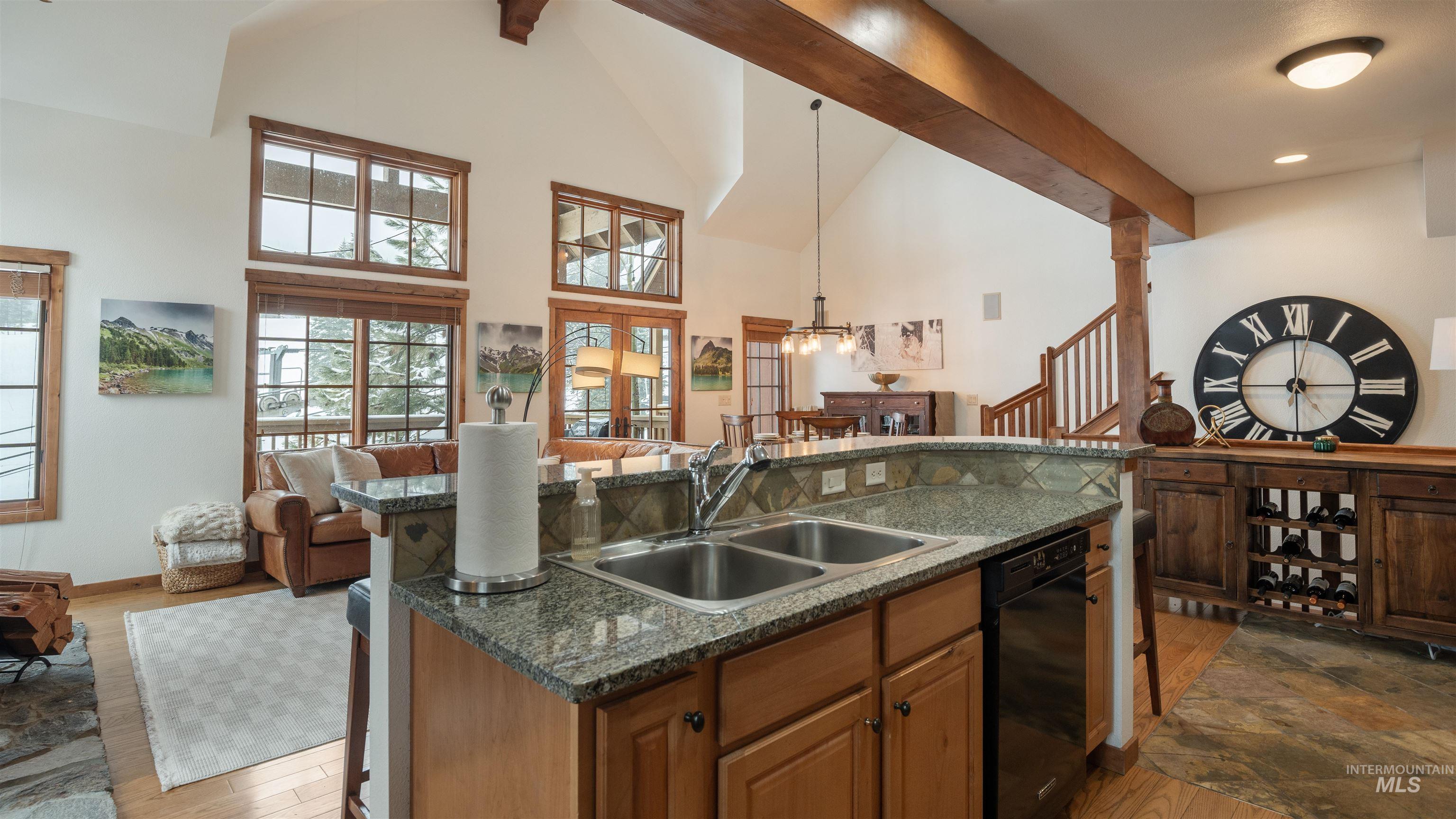 Kitchen with open floor plan, a kitchen breakfast bar, a kitchen island with sink, pendant lighting, and vaulted ceiling