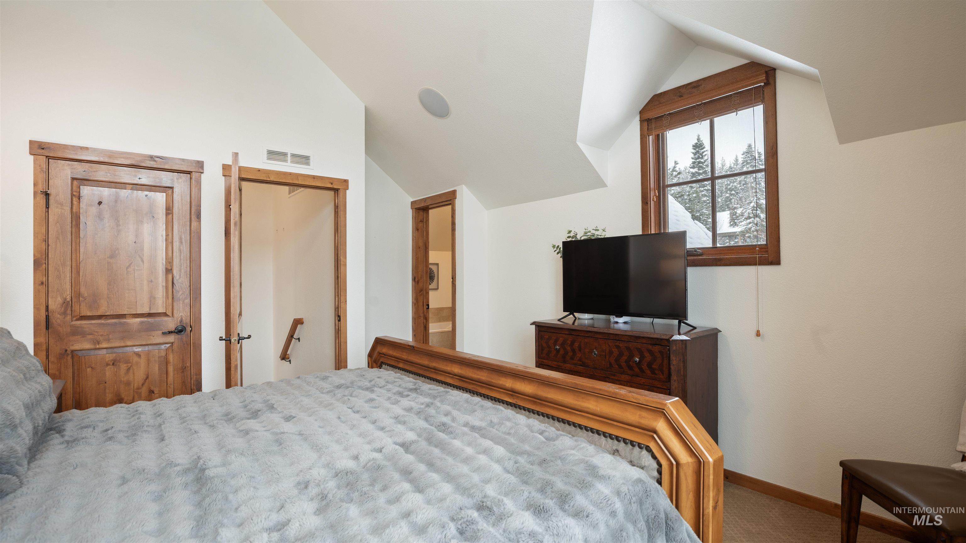Bedroom with carpet flooring, lofted ceiling, and a closet