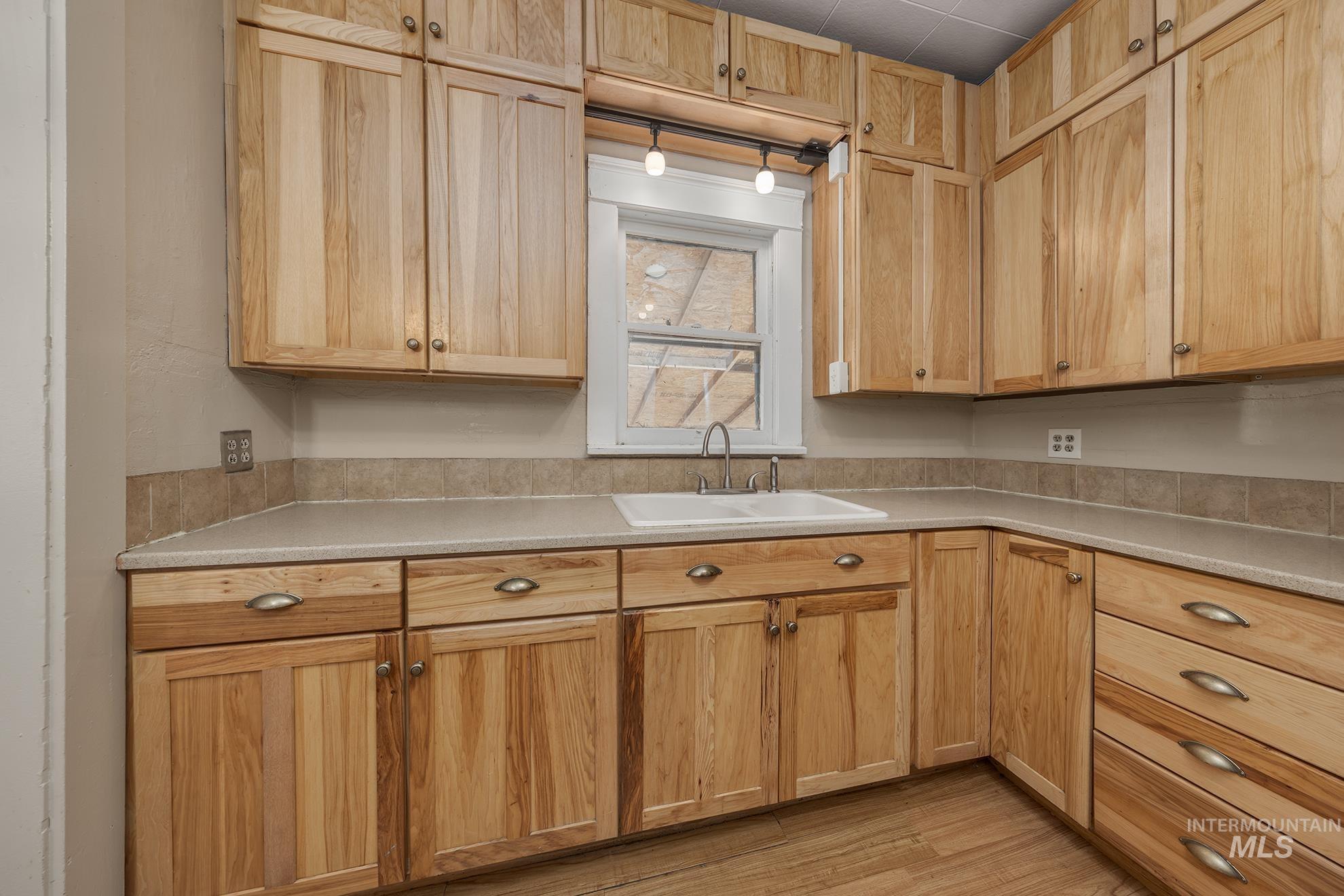 Kitchen featuring light countertops, light wood finished floors, and light brown cabinetry