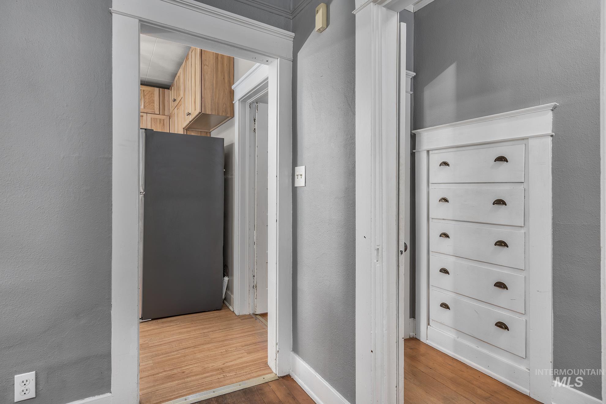 Hall with a textured wall and wood finished floors