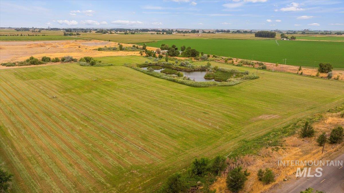 Overview of rural landscape featuring large plots for crops and a nearby body of water