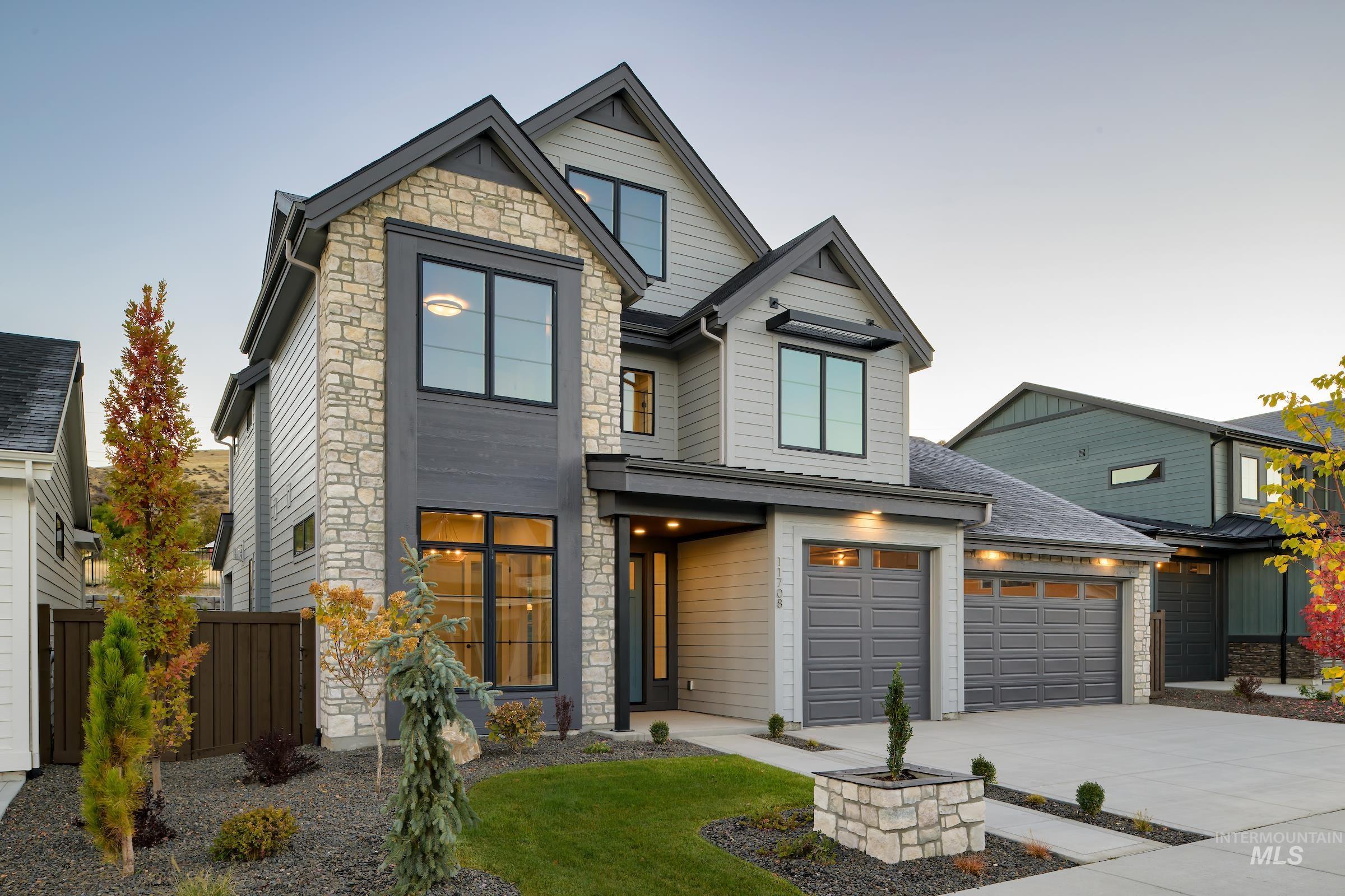 View of front of property with stone siding, driveway, and an attached garage