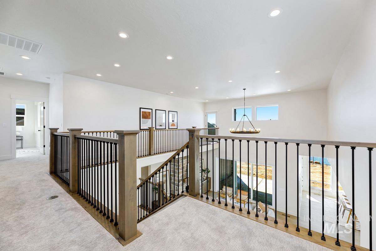 Hallway with recessed lighting, carpet, a chandelier, and an upstairs landing