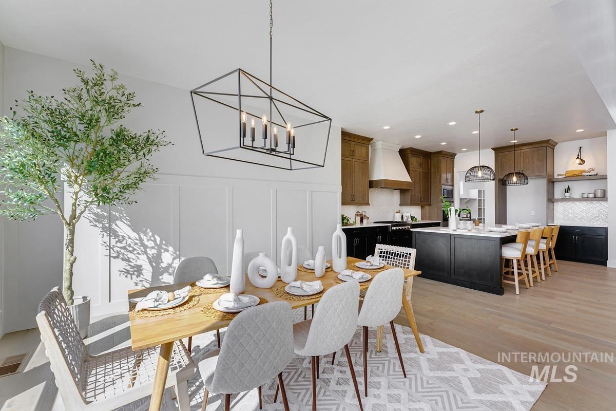 Dining room featuring a decorative wall, a chandelier, light wood-style flooring, and recessed lighting