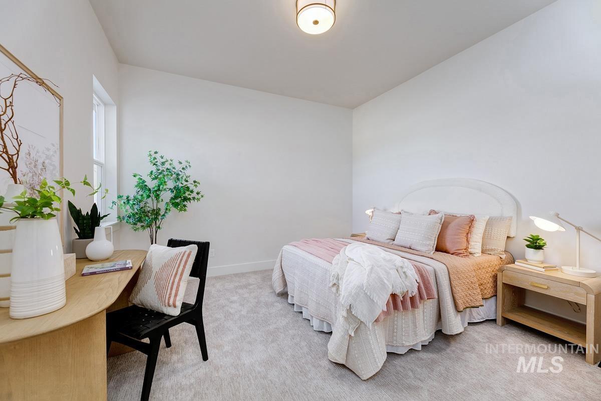 Bedroom with light colored carpet and baseboards