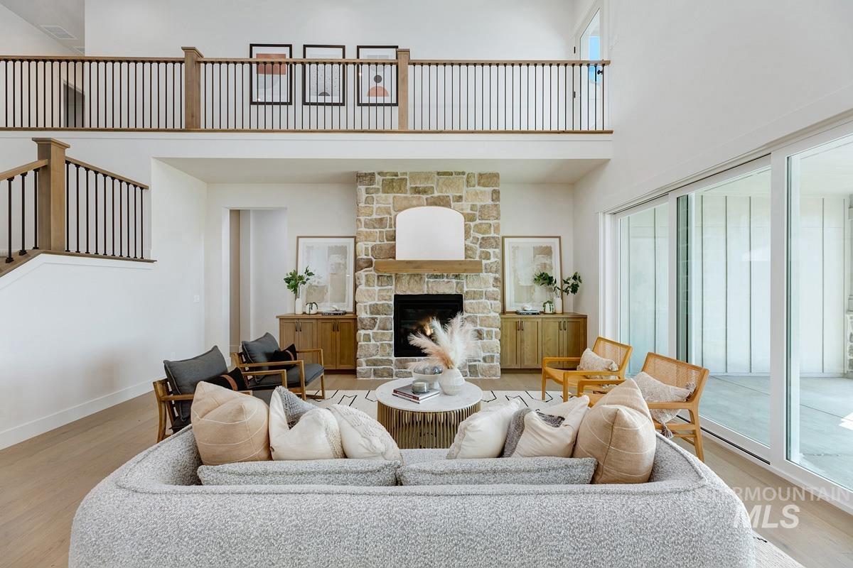 Living area featuring a high ceiling, a fireplace, and wood finished floors