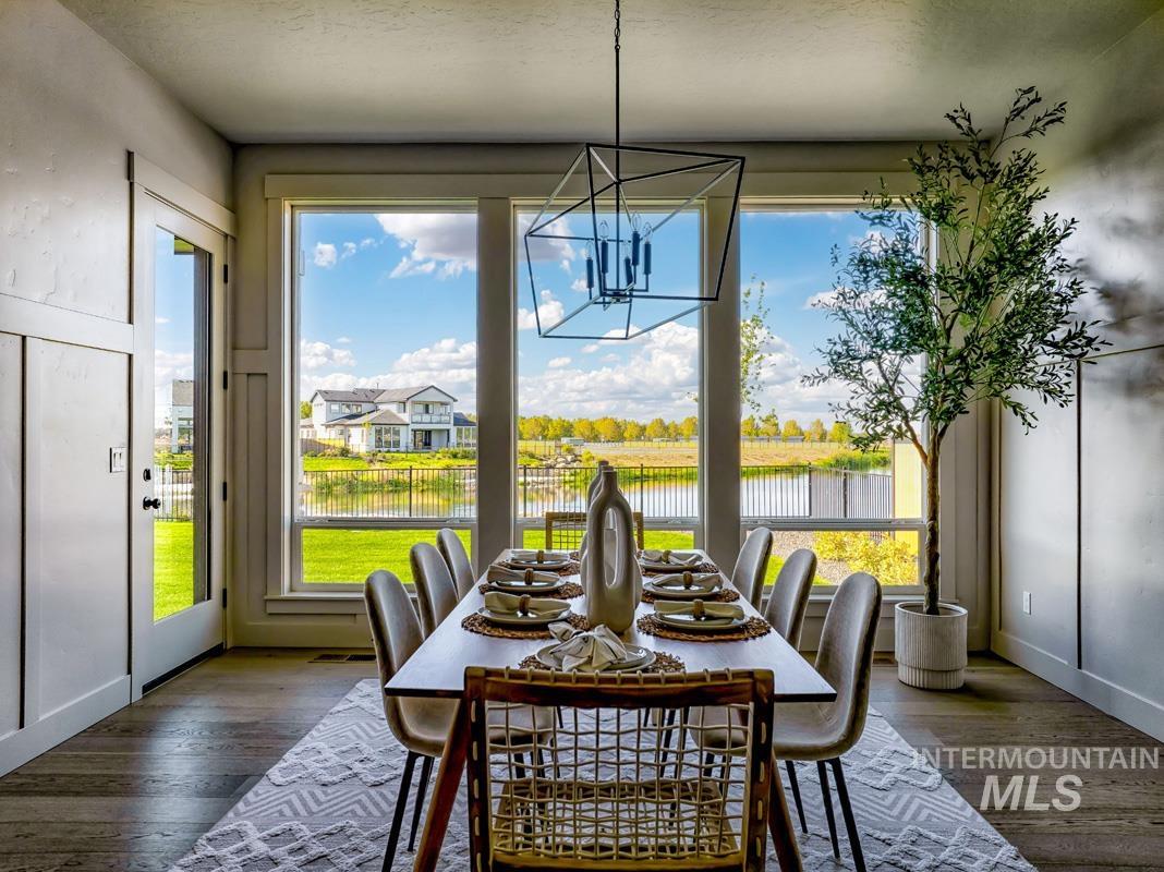 Dining room with plenty of natural light, a chandelier, hardwood / wood-style floors, and a water view