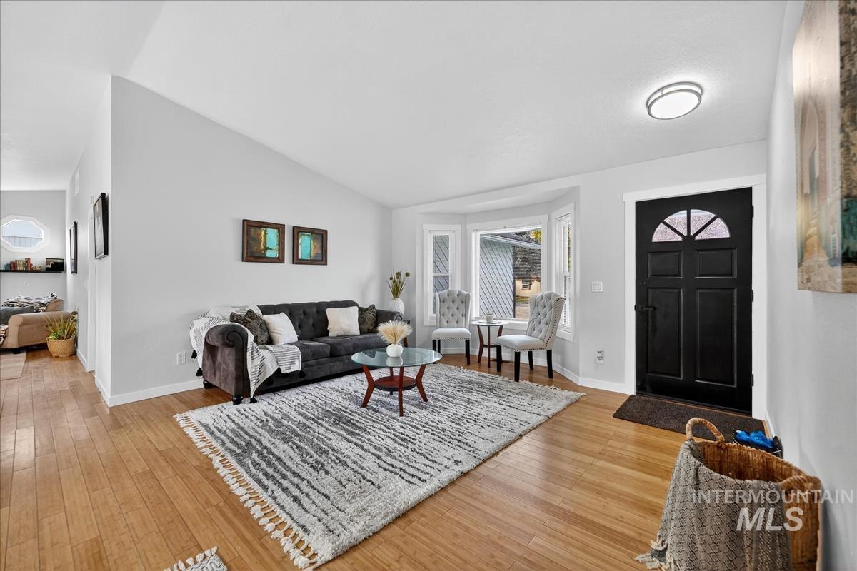 Living room featuring light wood-type flooring and lofted ceiling