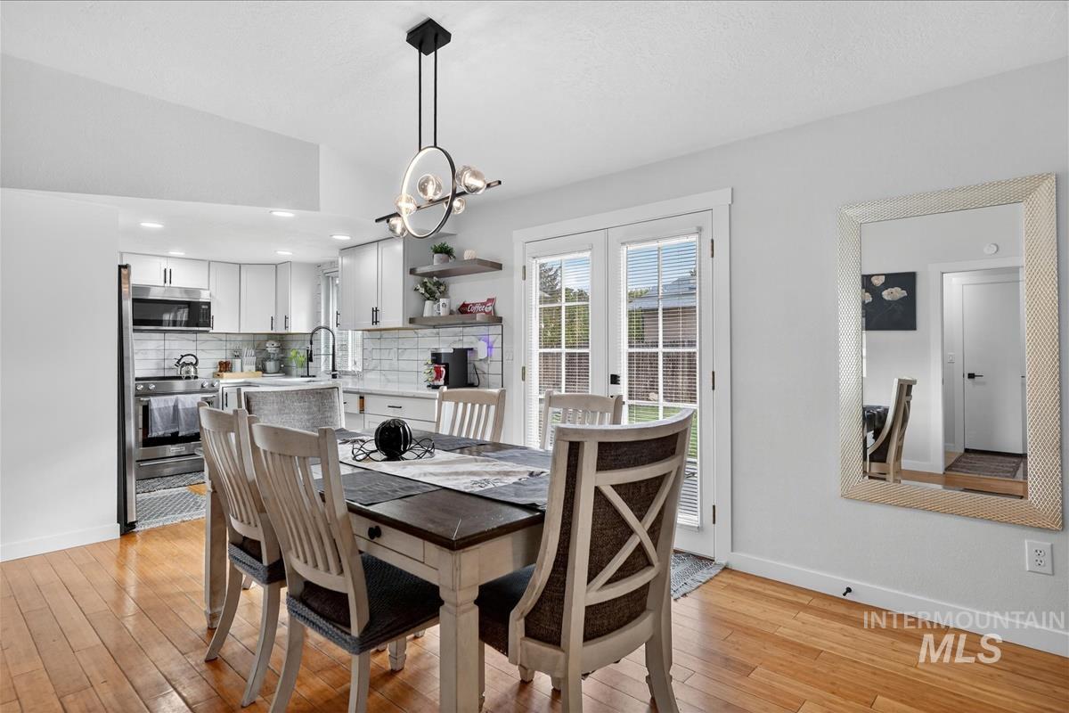 Dining space with light wood-type flooring and a chandelier