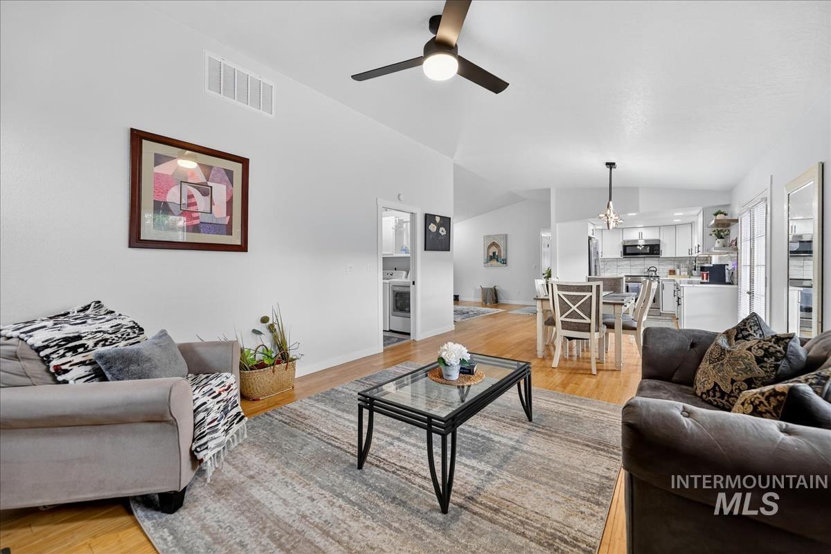 Living area with light wood finished floors, lofted ceiling, and ceiling fan