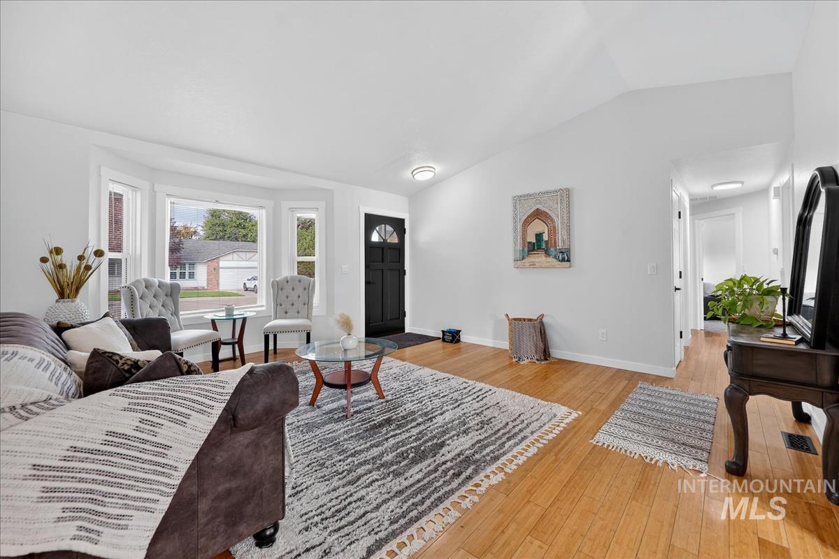 Living area featuring light wood finished floors and vaulted ceiling