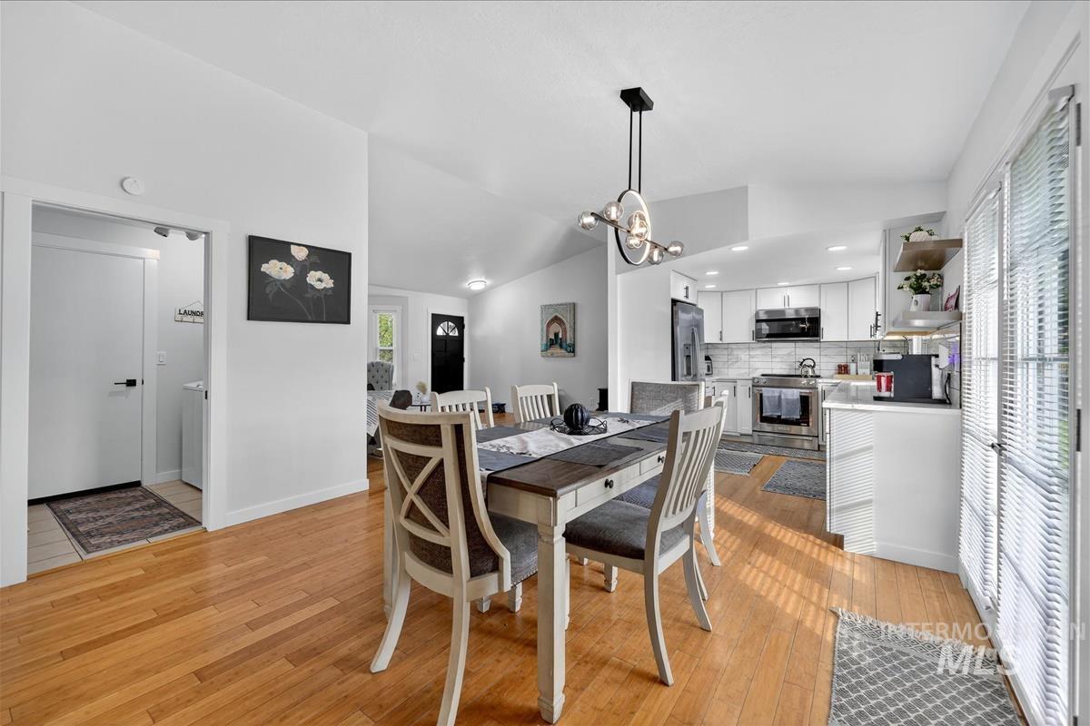 Dining space featuring lofted ceiling, light wood-style flooring, a chandelier, and recessed lighting