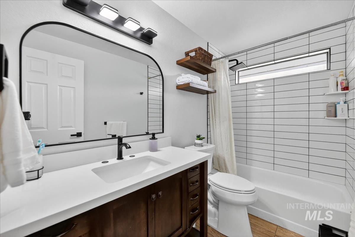 Full bathroom with shower / bath combo, vanity, and light wood-type flooring