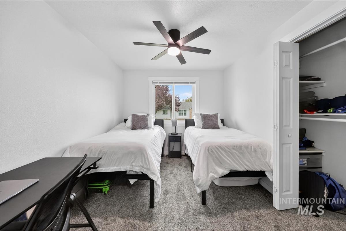 Bedroom featuring light colored carpet, a closet, and ceiling fan