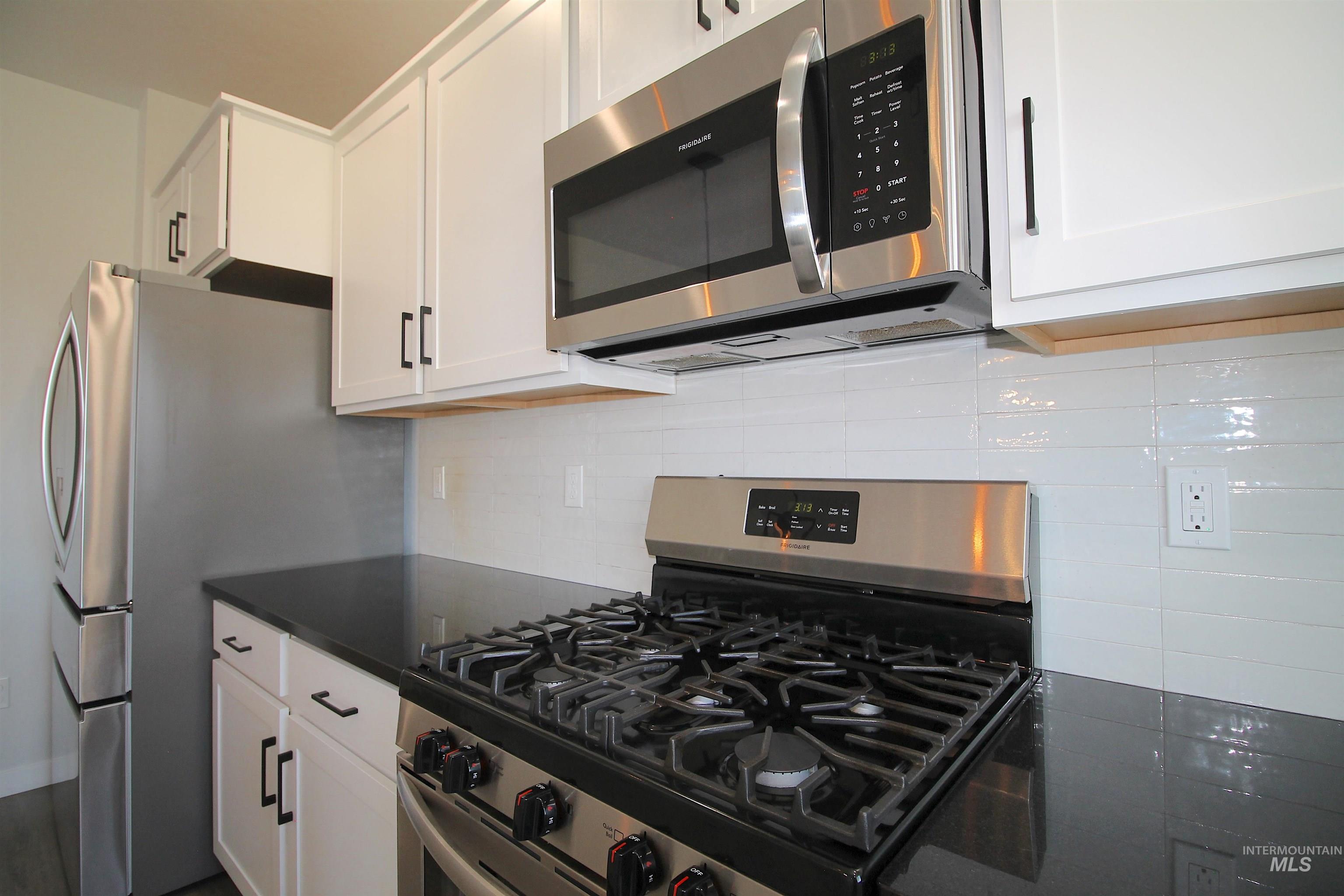 Stainless steel gas range with coordinating microwave above