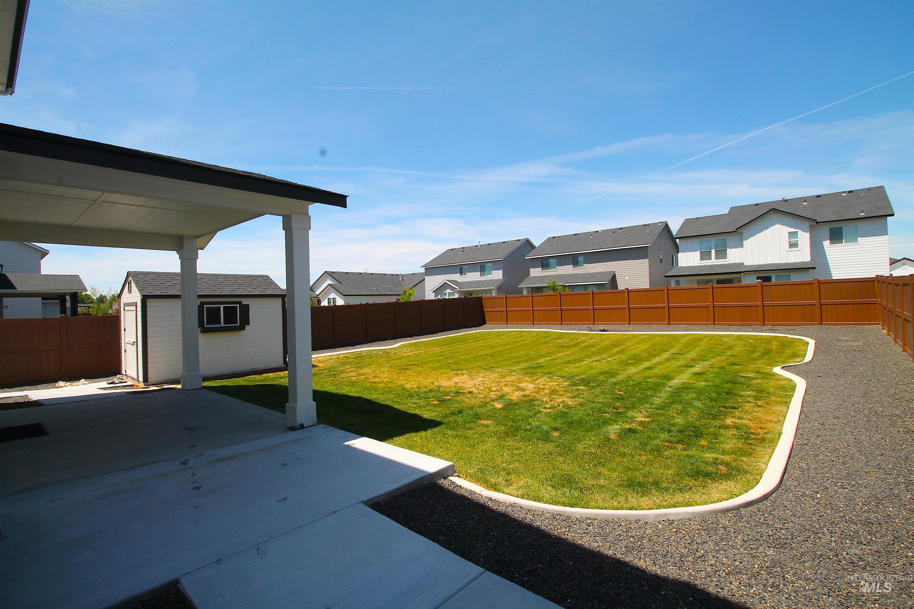 Covered concrete patio with white columns and a black trim roof