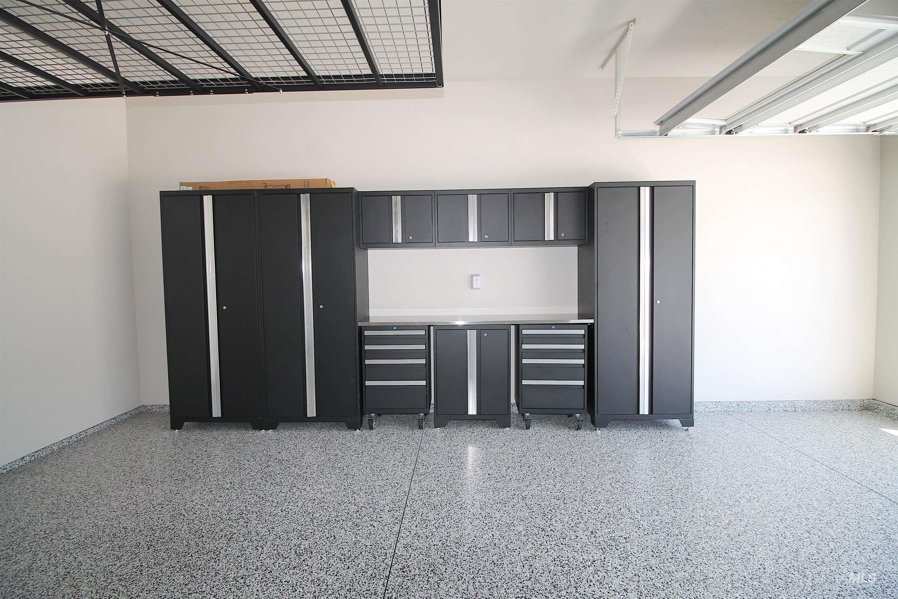Garage featuring epoxy flooring and built-in metal cabinetry