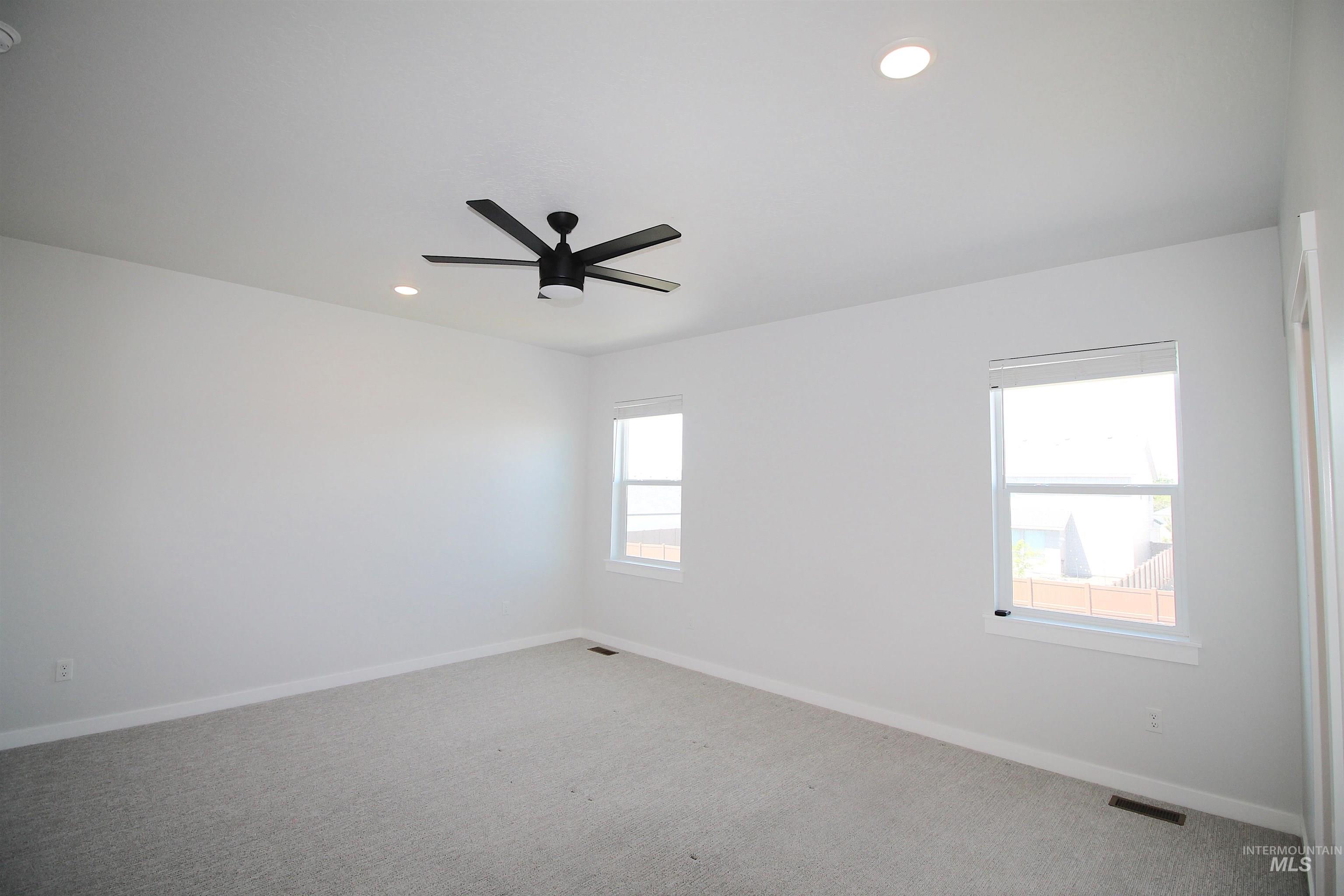 Spacious room with light gray carpeting and white walls
