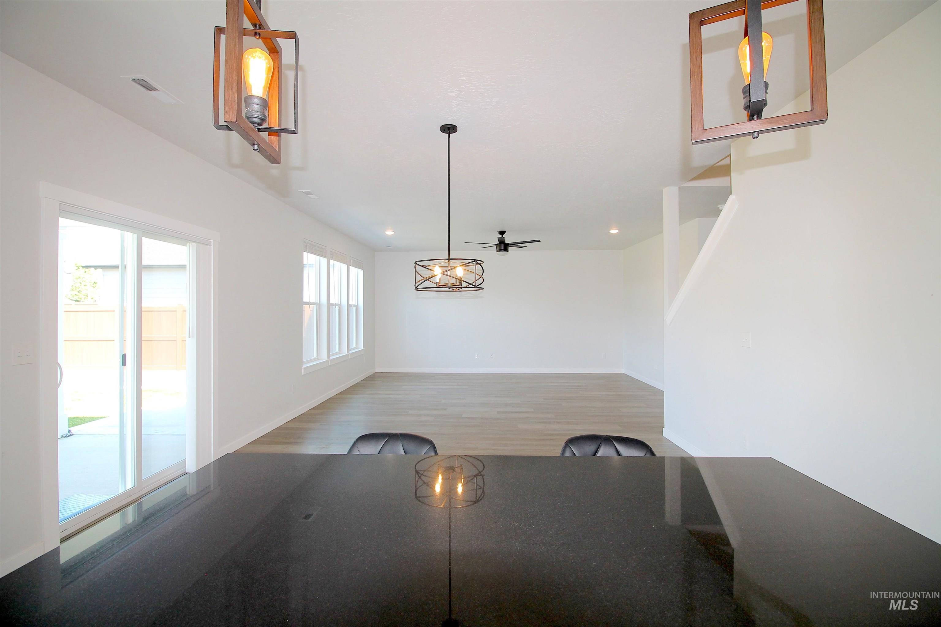 Expansive open-concept living space featuring wood-finish flooring, recessed lighting, and a ceiling fan