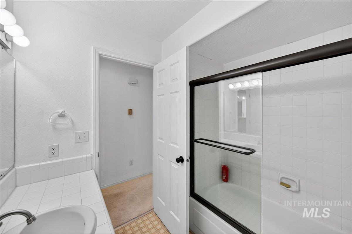 Bathroom with enclosed tub / shower combo and vanity