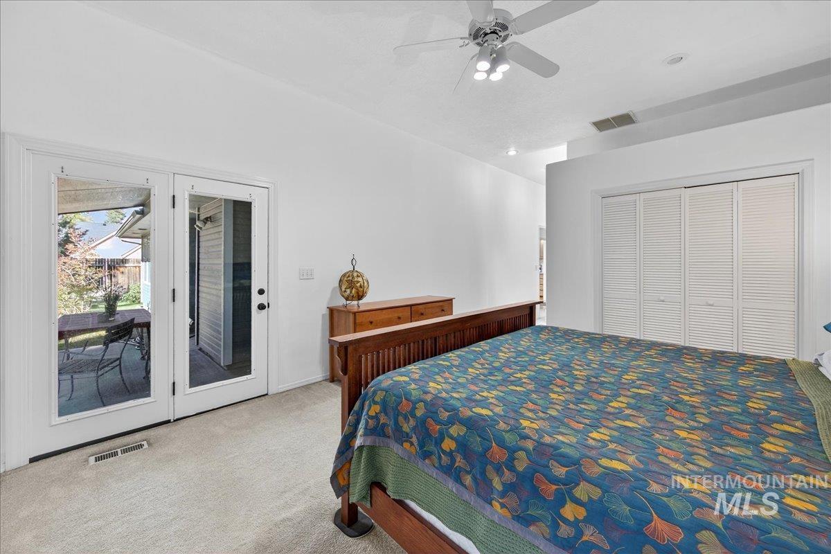 Carpeted bedroom with access to outside, ceiling fan, and a closet