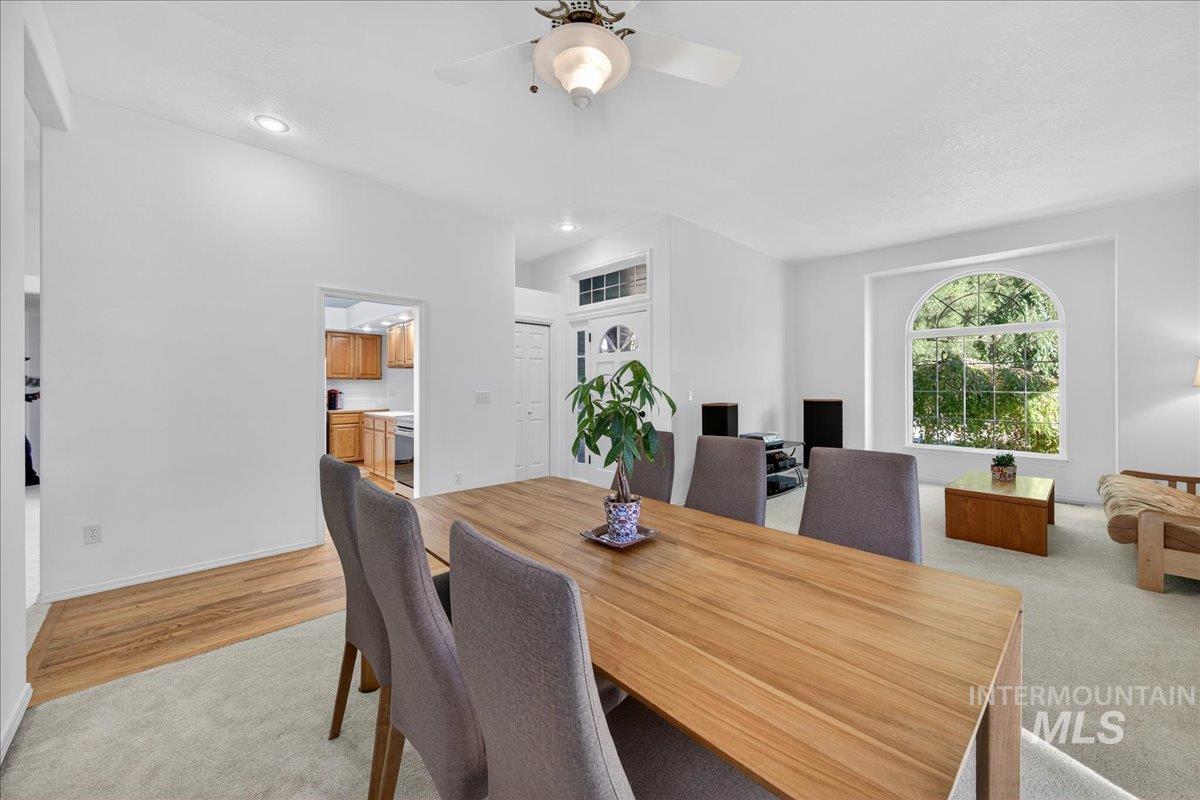 Dining room with a ceiling fan, recessed lighting, light wood finished floors, and light carpet