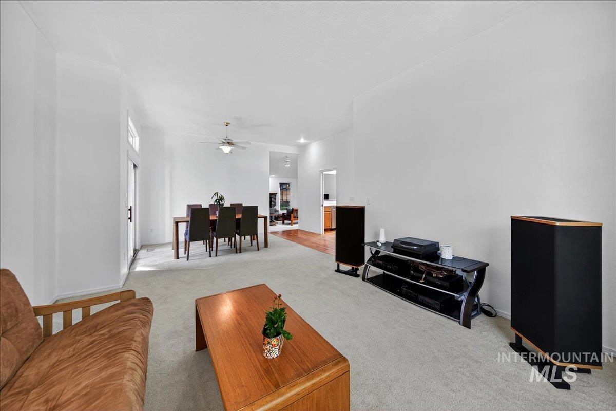 Living area with carpet floors and a ceiling fan
