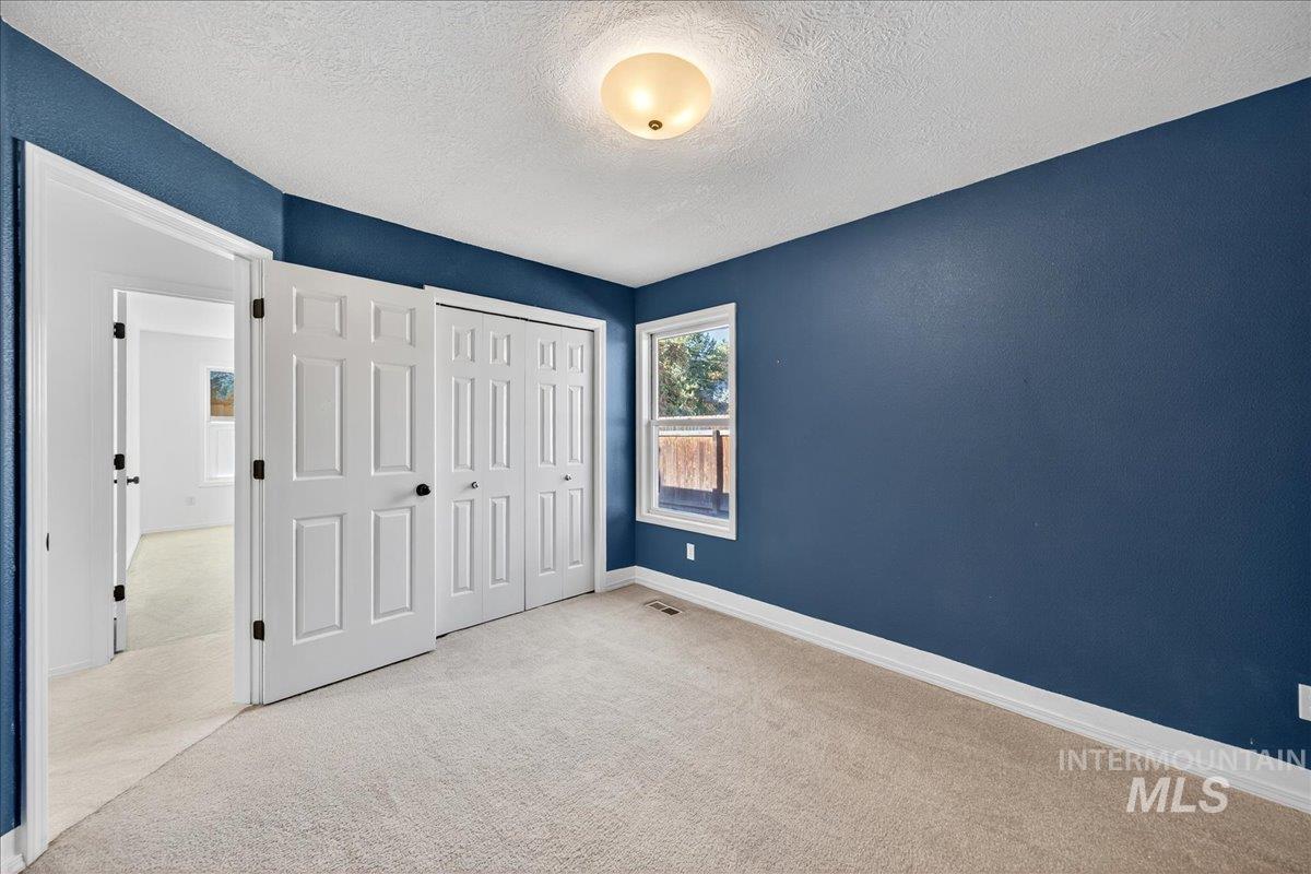 Unfurnished bedroom with carpet flooring, a textured ceiling, and a closet