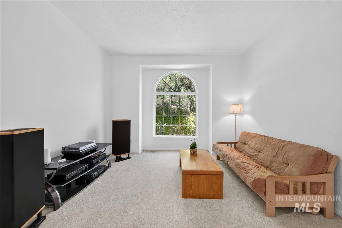 Carpeted living area featuring a textured ceiling