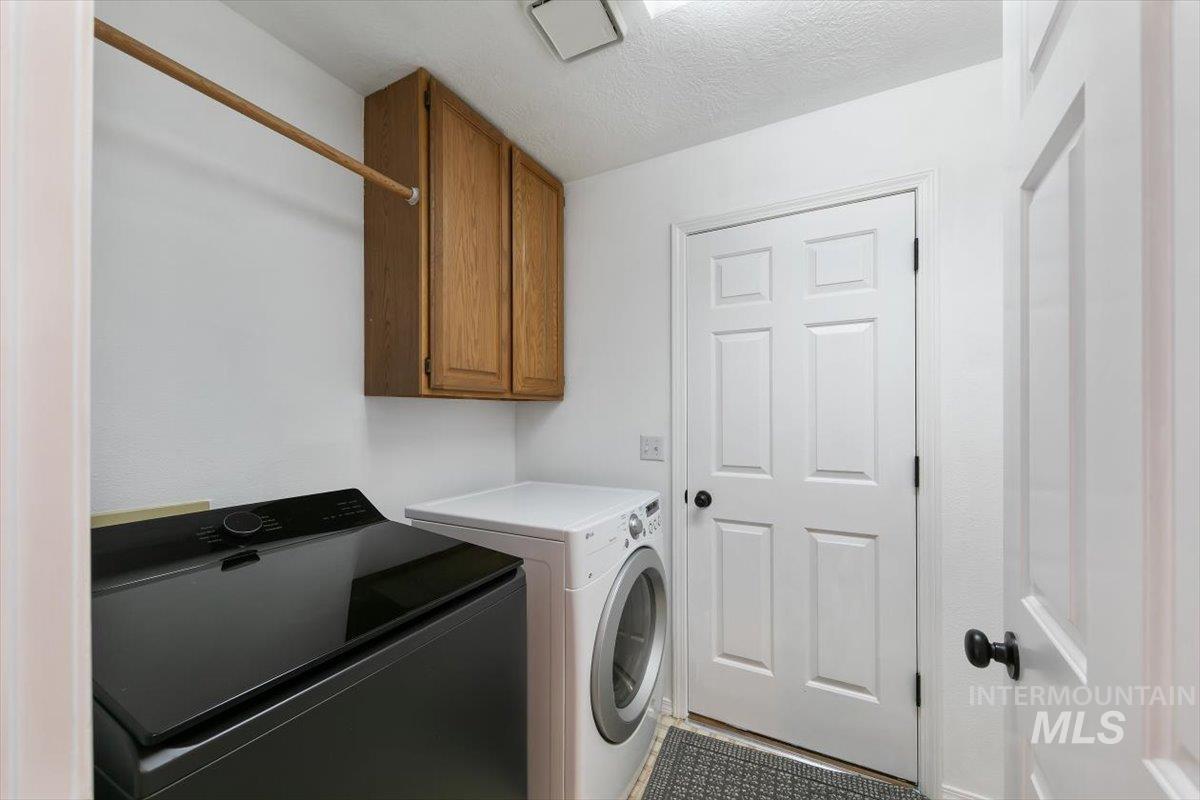 Washroom with cabinet space, separate washer and dryer, and a textured ceiling