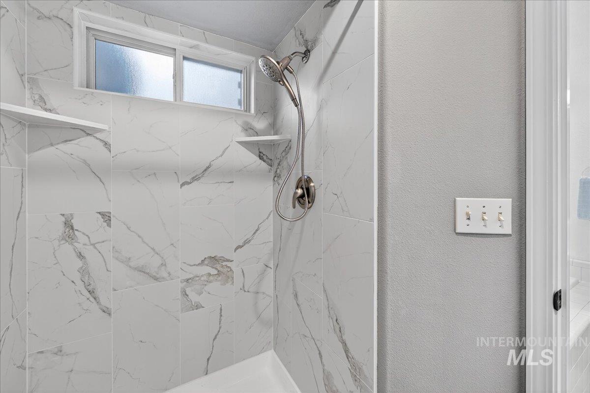 Bathroom featuring a marble finish shower