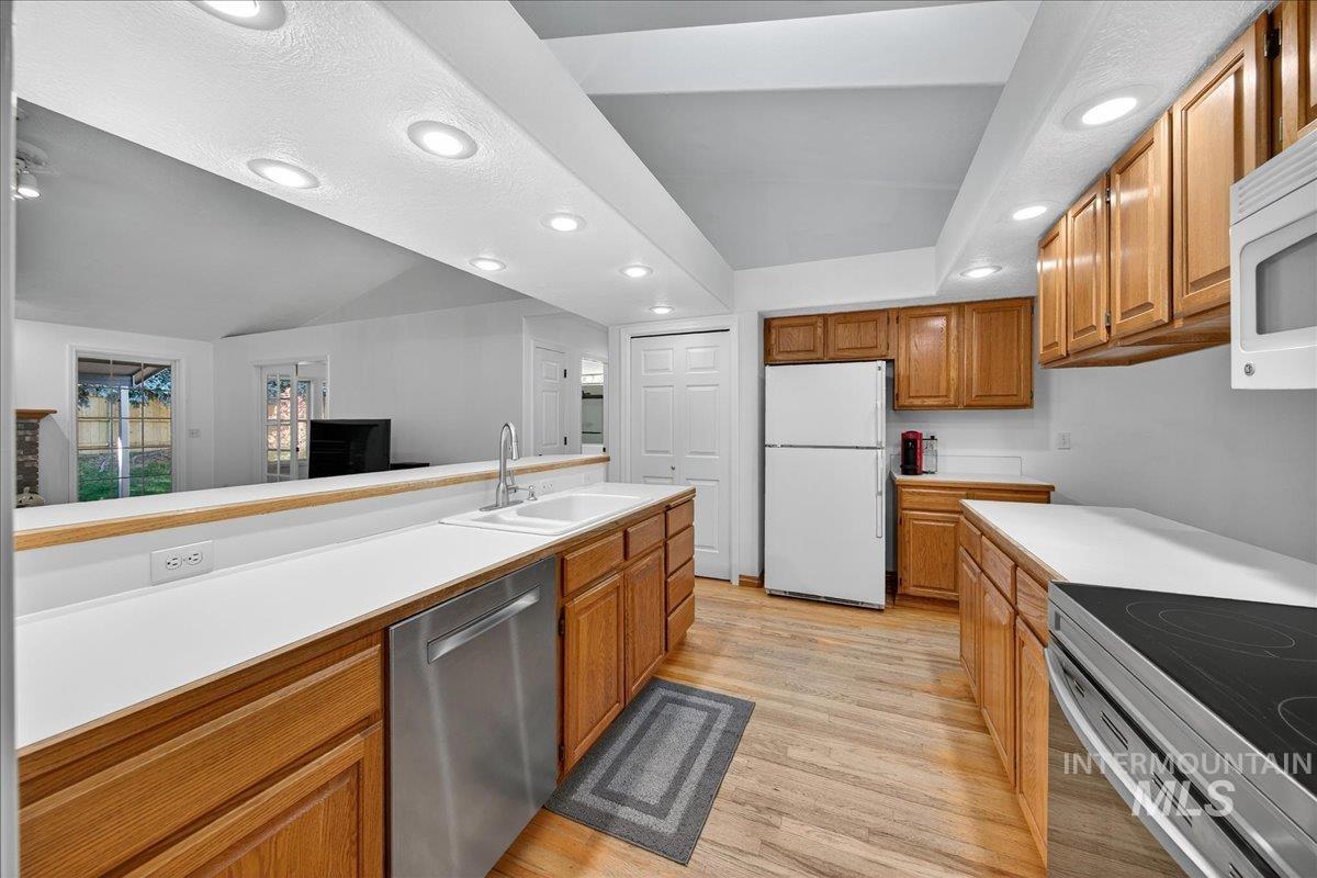 Kitchen featuring recessed lighting, brown cabinets, stainless steel appliances, light wood-style flooring, and light countertops