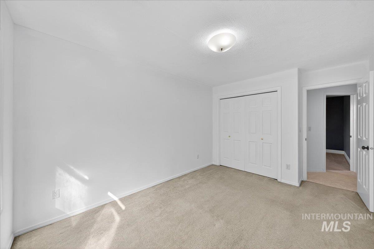 Unfurnished bedroom with carpet, a textured ceiling, and a closet