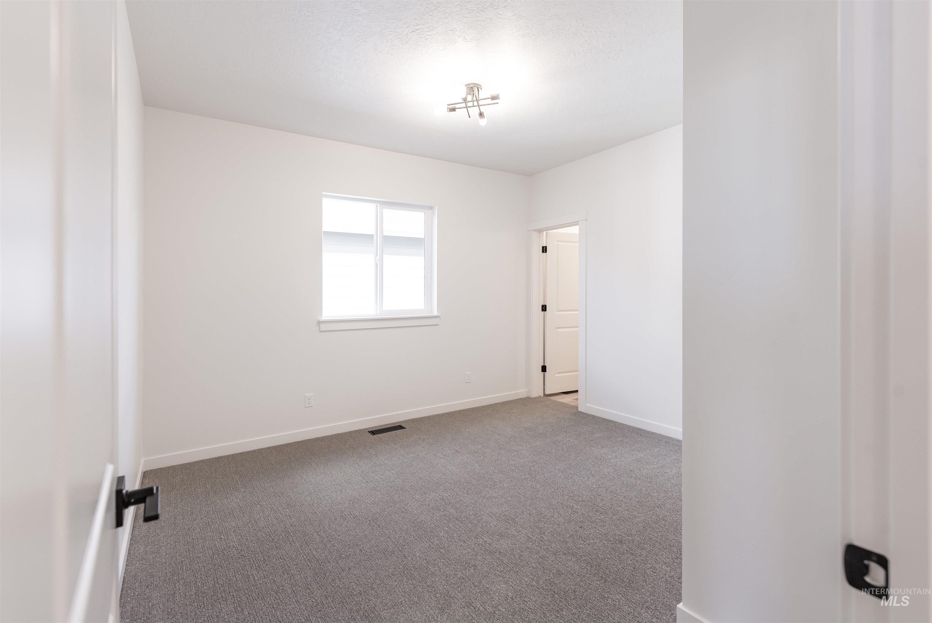 Spare room featuring carpet floors and baseboards
