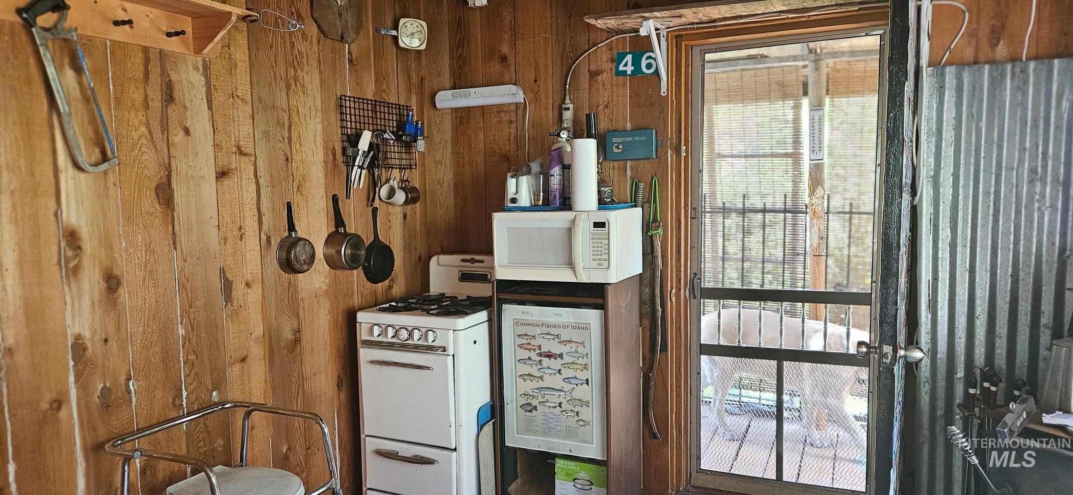 Kitchen with wood walls and white appliances