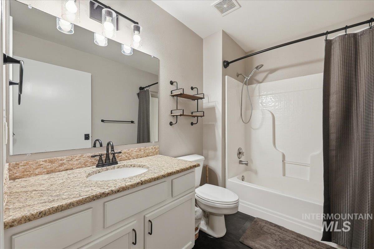 Bathroom featuring shower / bathtub combination with curtain and vanity