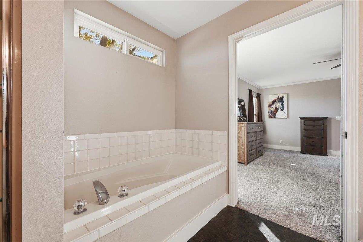Bathroom with a bath and dark carpet