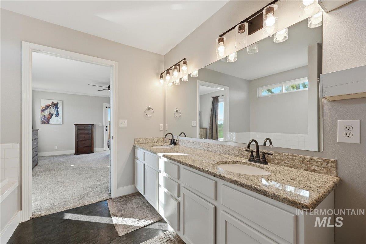 Full bathroom with double vanity and a ceiling fan
