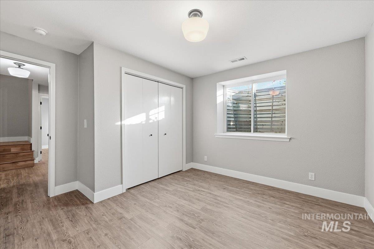 Unfurnished bedroom featuring light wood finished floors and a closet