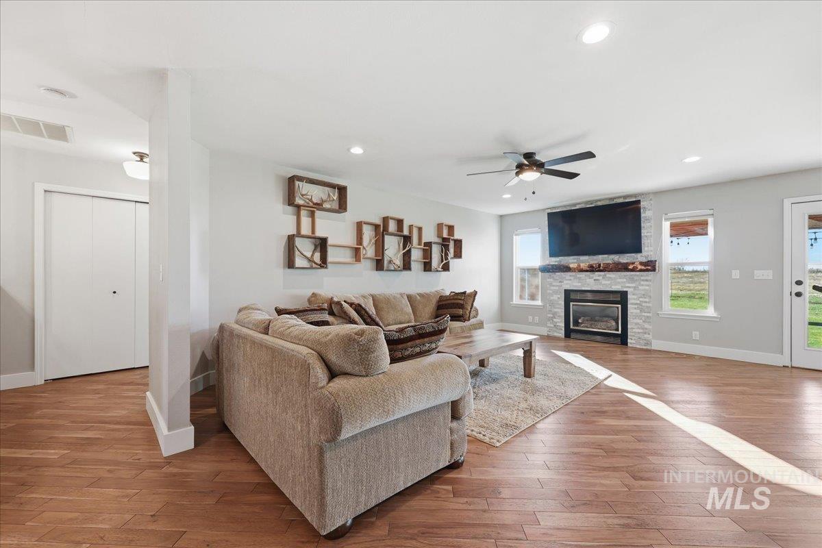Living area featuring light wood finished floors, recessed lighting, a ceiling fan, and a fireplace