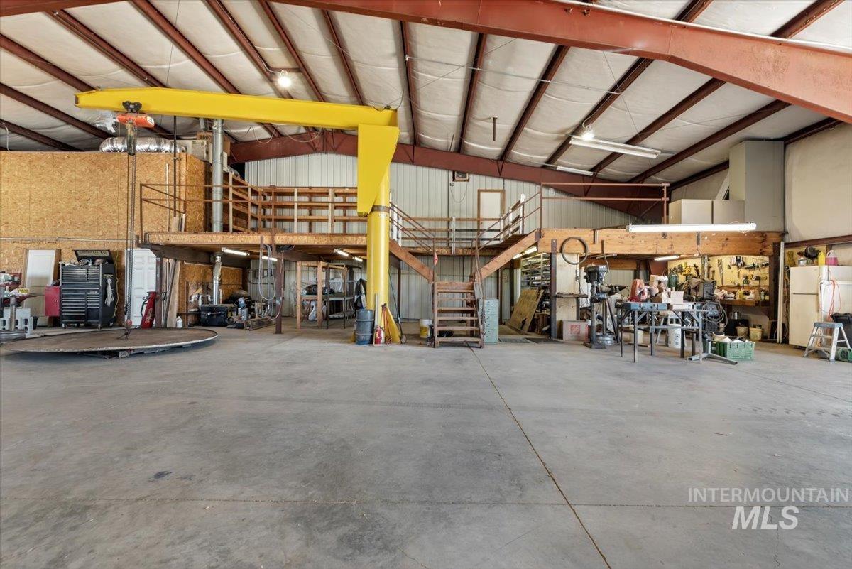 Garage featuring freestanding refrigerator and a workshop area