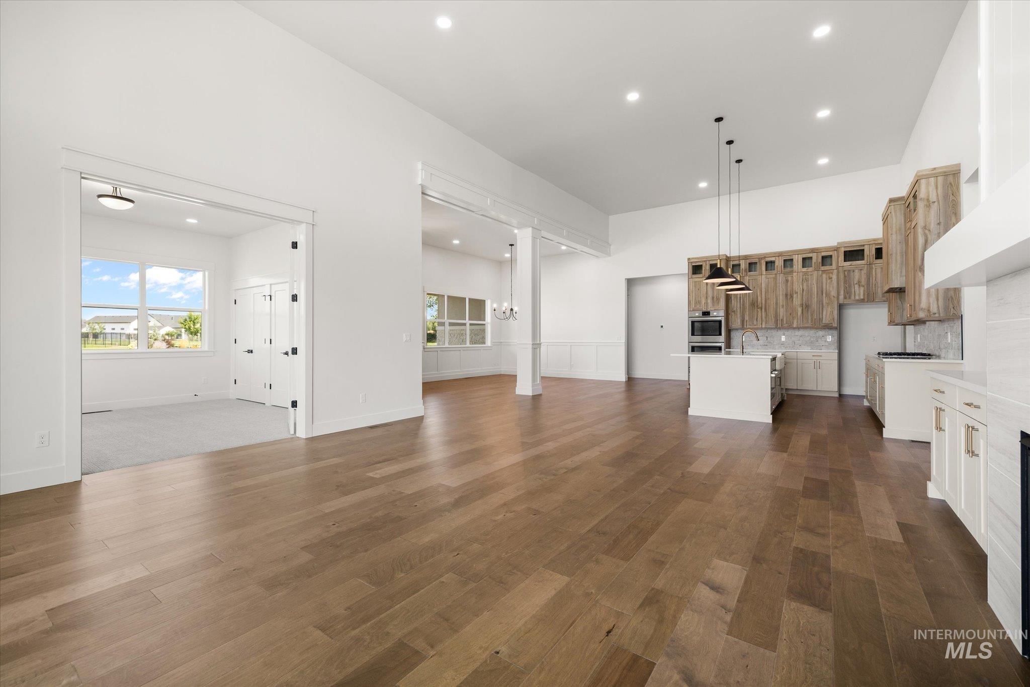Unfurnished living room with recessed lighting and dark wood-style flooring