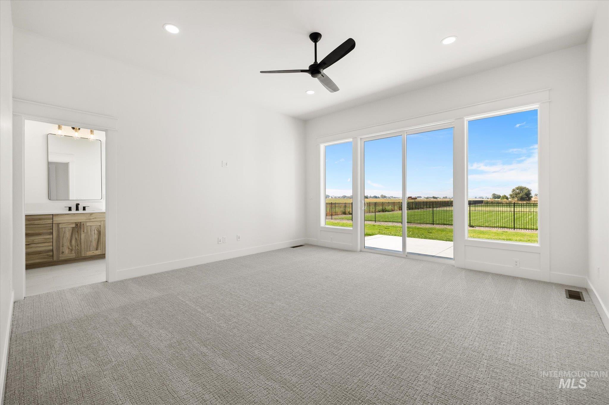 Bedroom featuring light colored carpet, recessed lighting, a ceiling fan, ensuite bath, and access to outside