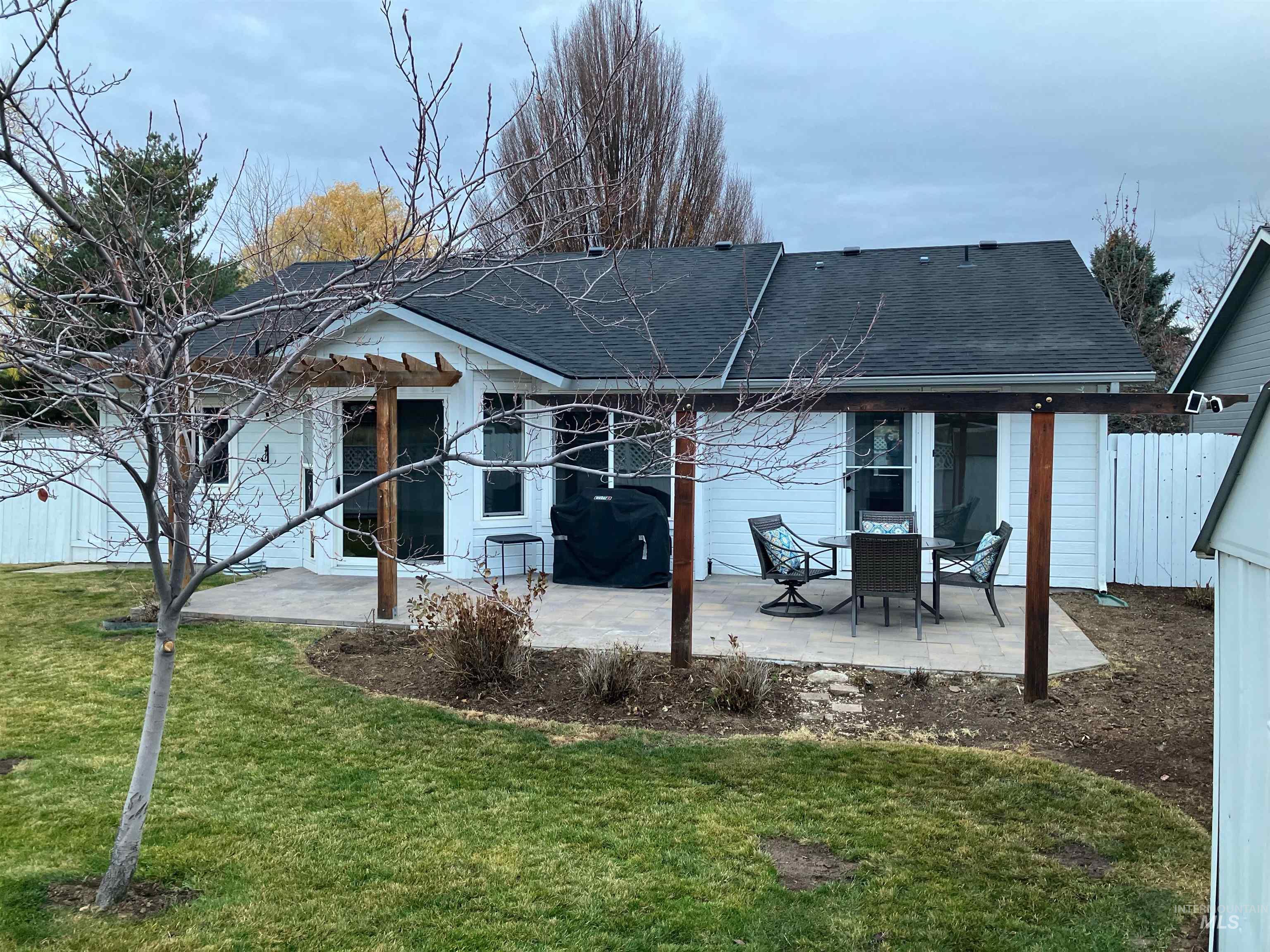 Back of property featuring roof with shingles and a patio