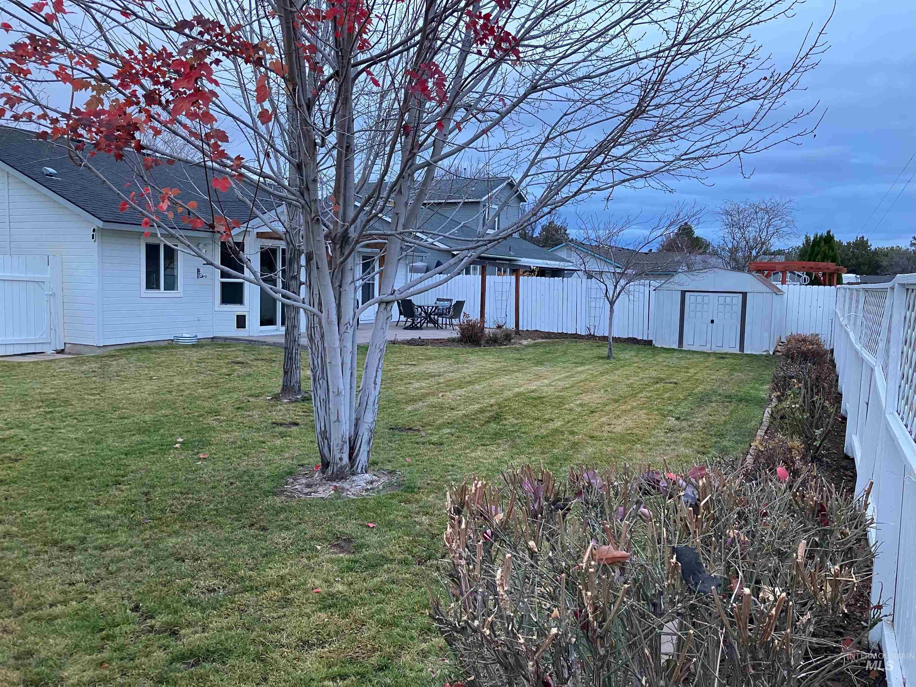 Fenced backyard with a shed and a patio