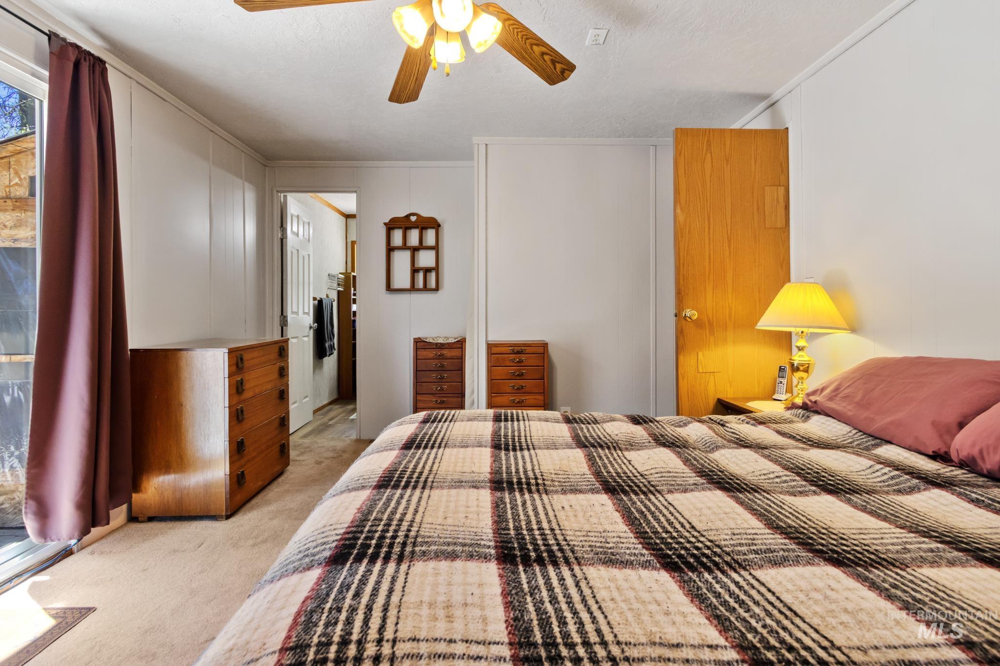 Carpeted flooring throughout, featuring a ceiling fan with integrated lighting