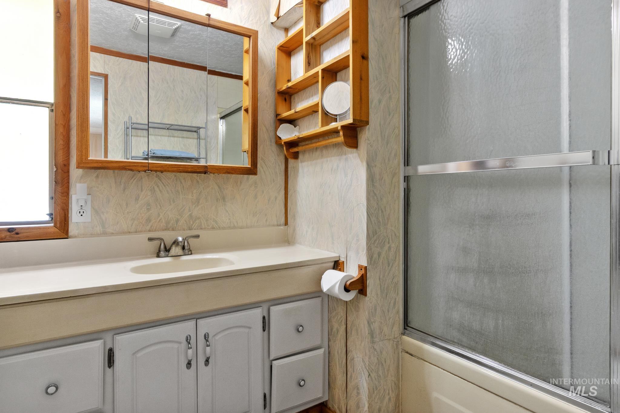 Bathroom vanity with an integrated sink, polished chrome faucet, and white cabinetry
