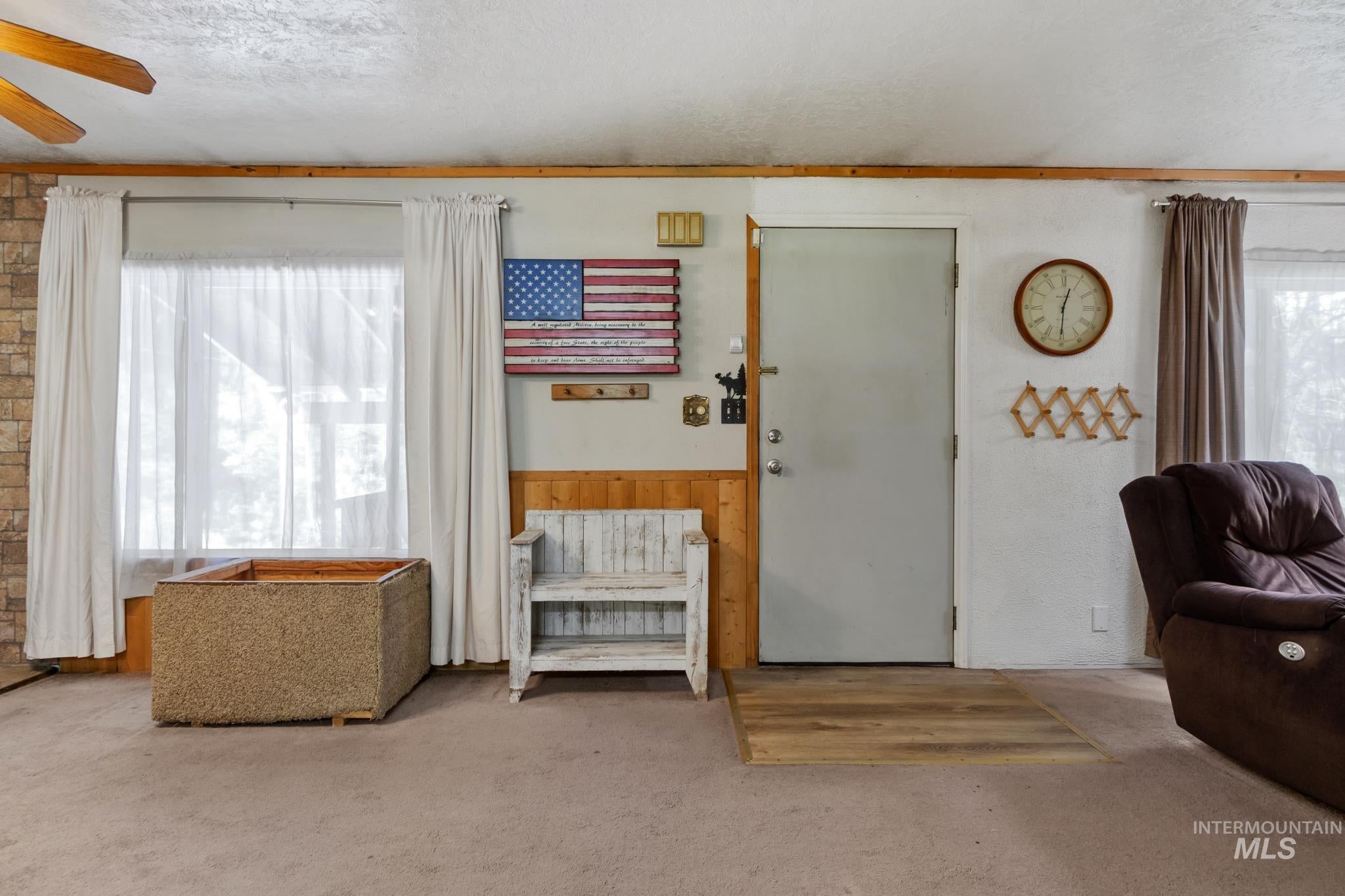 Light-colored wall paneling and a light wood-finish flooring section at the entry