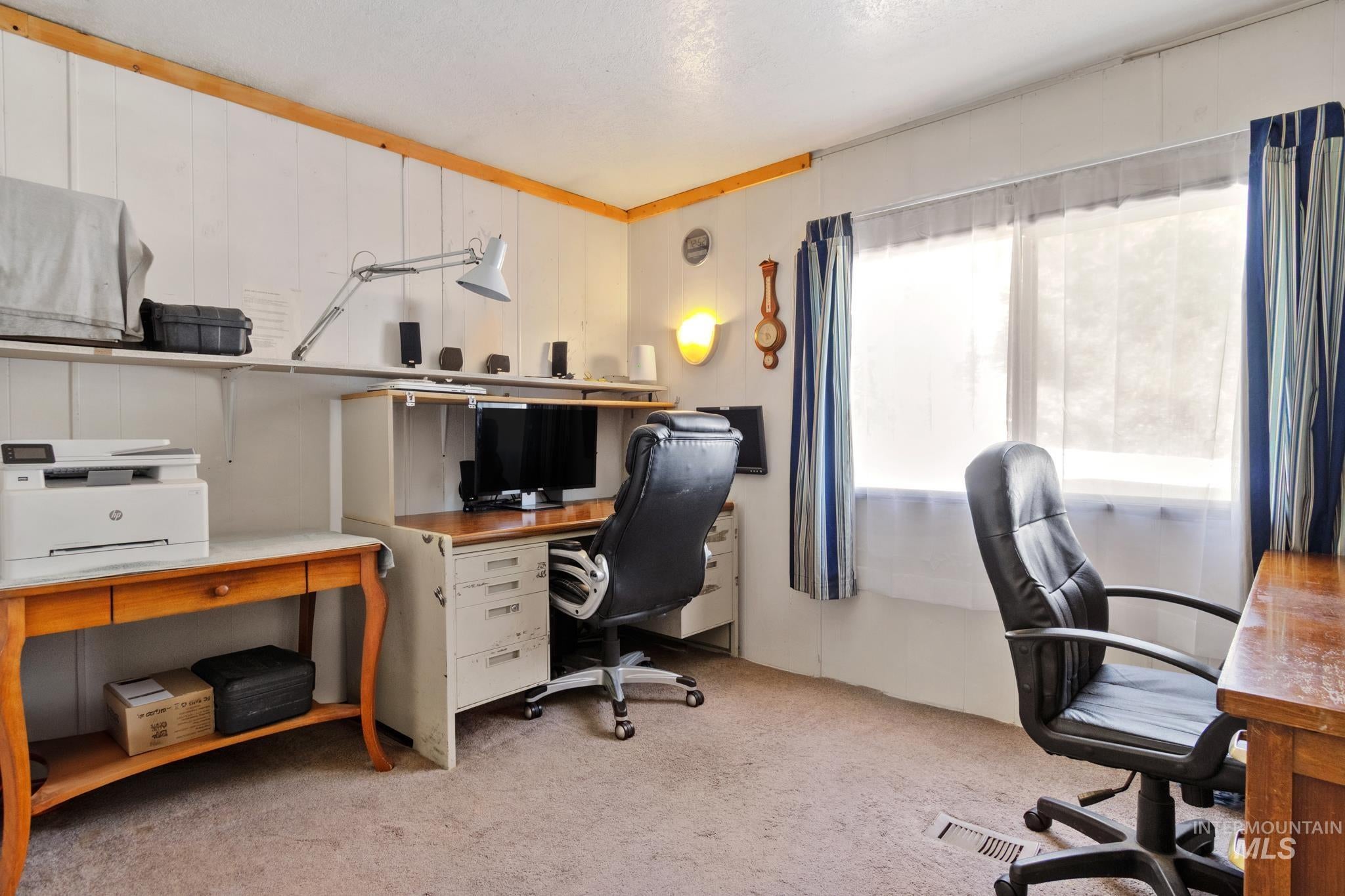Dedicated workspace featuring wall paneling and neutral carpeting